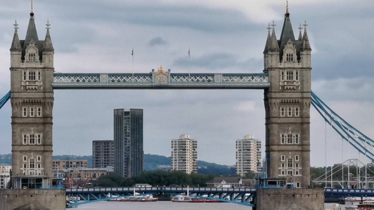 Tower Bridge seen front-on from the riverside, its two stone towers joined by high walkways